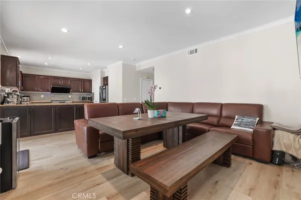 a kitchen with stainless steel appliances a sink dishwasher a refrigerator a microwave oven with cabinets and wooden floor