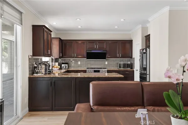 a kitchen with stainless steel appliances granite countertop a refrigerator a stove top oven a sink and dishwasher