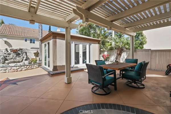 a view of a patio with table and chairs potted plants and palm trees