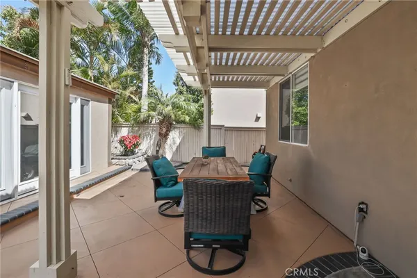 a view of a patio with table and chairs potted plants and a large tree