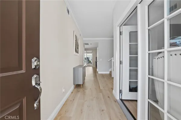 a view of a hallway with wooden floor and staircase