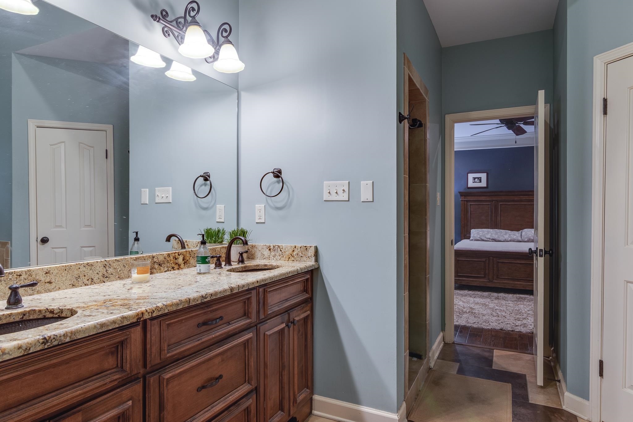 791 North Tree Drive Collierville, TN 38017 - Photo 14 of 27 Double vanity with granite countertop and dual undermount sinks, bronze finish faucets, and dark wood cabinetry