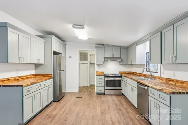 a kitchen with stainless steel appliances granite countertop a stove and white cabinets