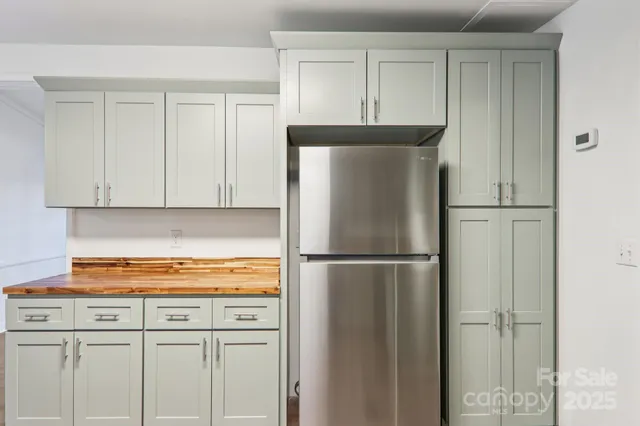 a kitchen with white cabinets and refrigerator