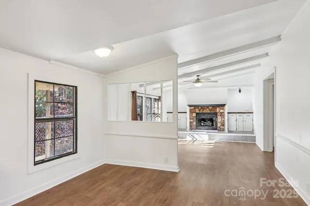 a view of an empty room with a fireplace and a window