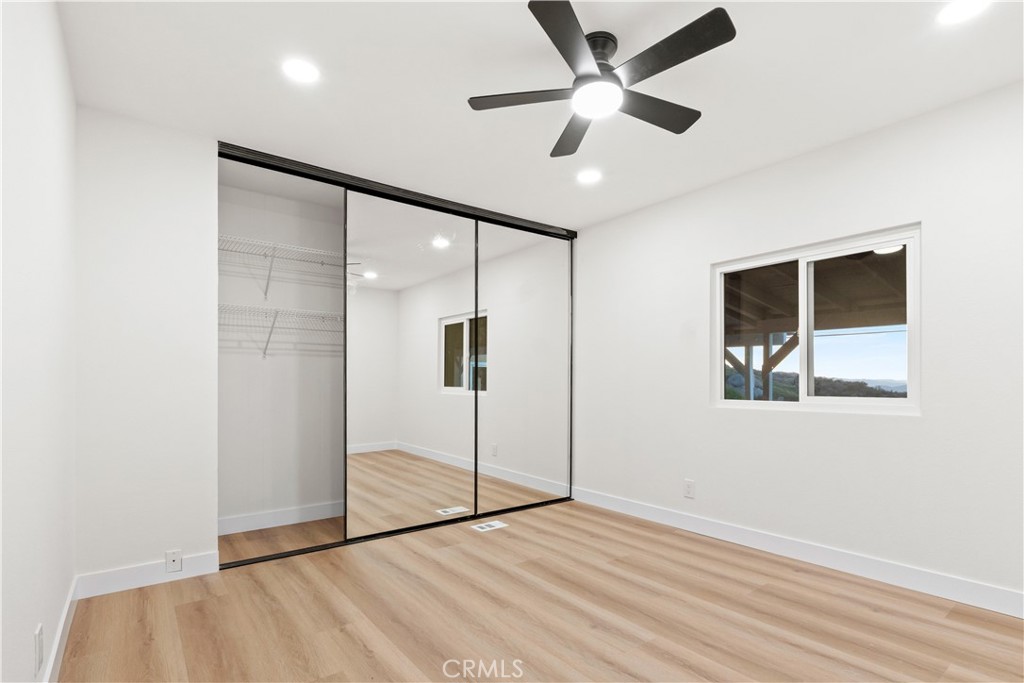 33195 Meyer Road Nuevo, CA 92567 - Photo 17 of 36 a view of an empty room with wooden floor and a ceiling fan