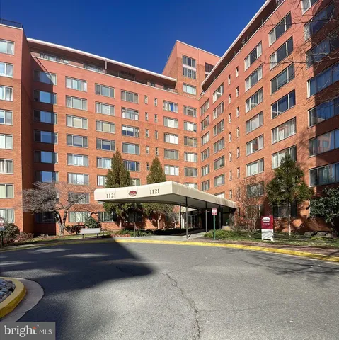 a front view of building with cars parked