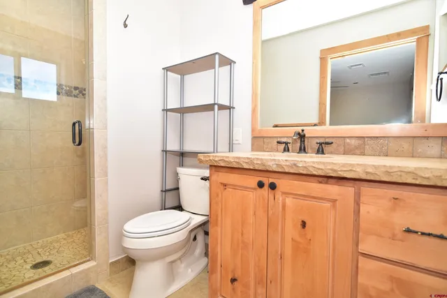 a bathroom with a granite countertop sink toilet and shower