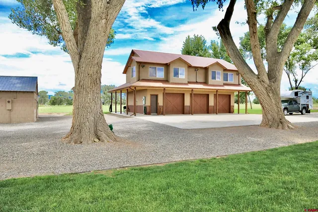 a white house that has tree in front of a yard