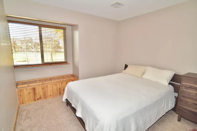 a large bed sitting in a bedroom next to a window