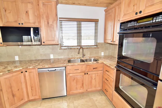 a kitchen with white cabinets and appliances