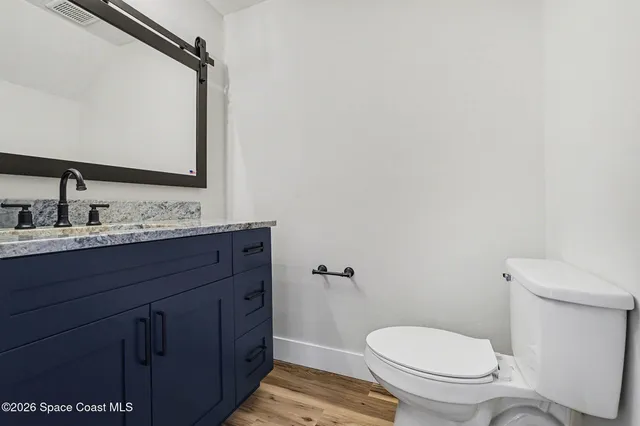a bathroom with a granite countertop toilet sink and mirror