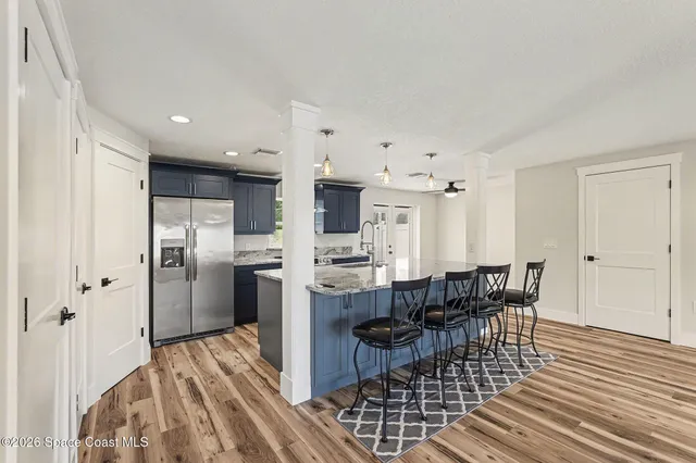 a living room with furniture and a dining table with kitchen view