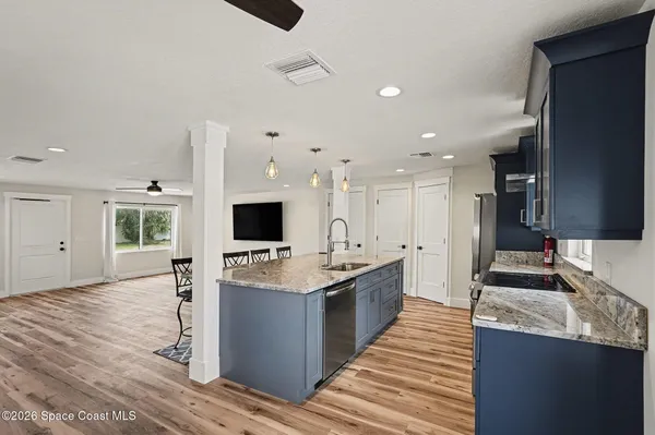 a large kitchen with stainless steel appliances kitchen island granite countertop a large counter top and sink