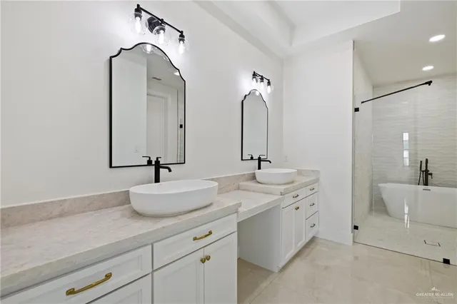 a bathroom with a double vanity sink mirror and bathtub