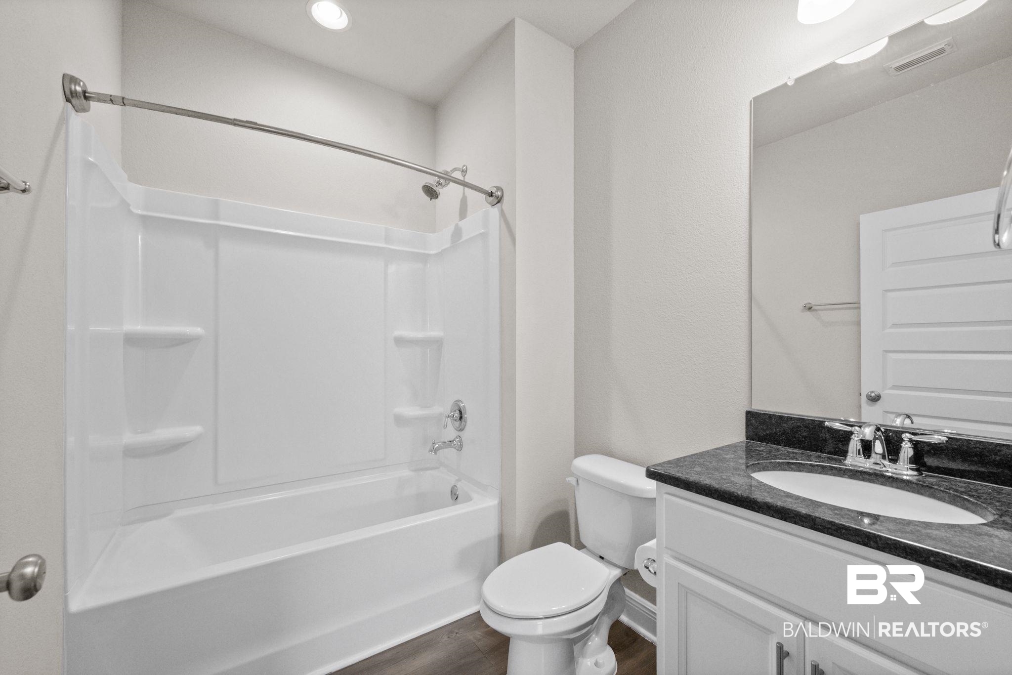 2074 Bourbon Street Foley, AL 36535 - Photo 32 of 46 Full bathroom featuring vanity, toilet, wood-type flooring, and shower / tub combination