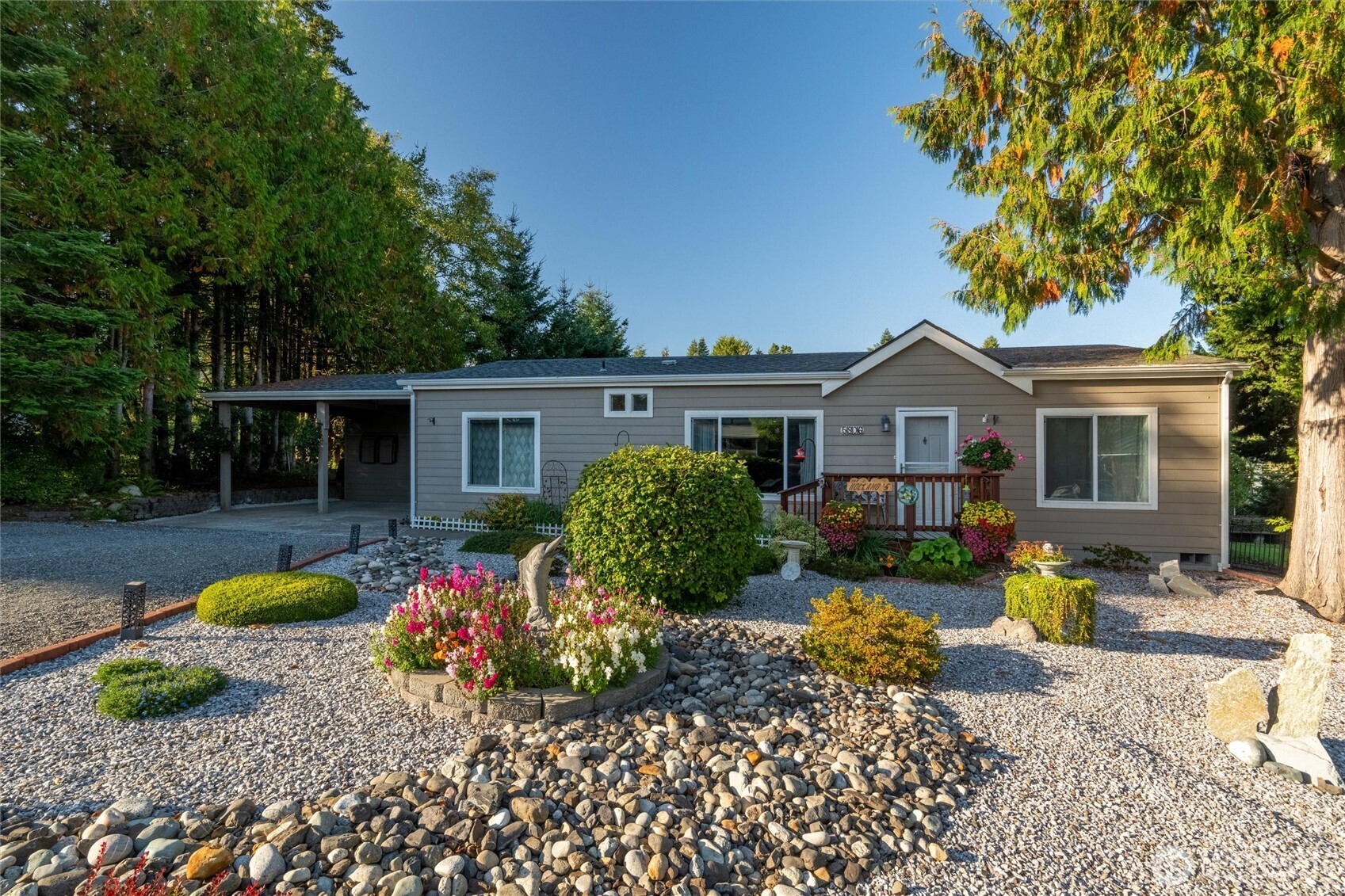 a front view of house with yard and trees in the background