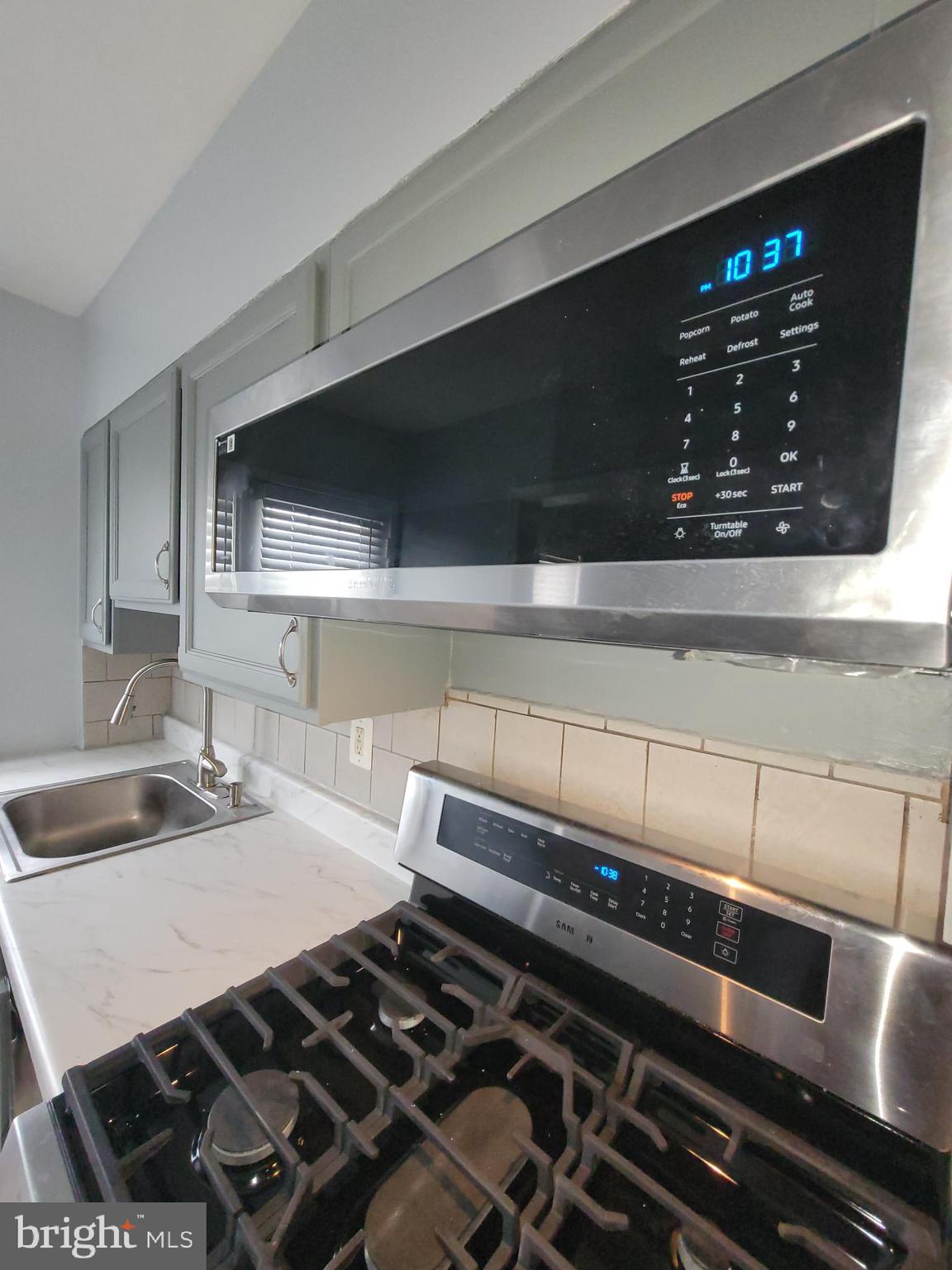 574 Brisbane Road Baltimore, MD 21229 - Photo 11 of 38 a kitchen with a stove and a microwave