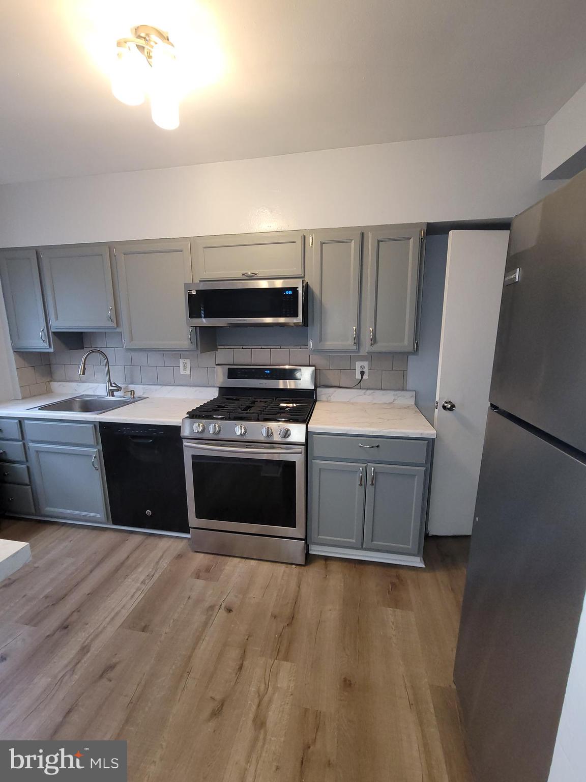 574 Brisbane Road Baltimore, MD 21229 - Photo 12 of 38 a kitchen with a stove and a refrigerator