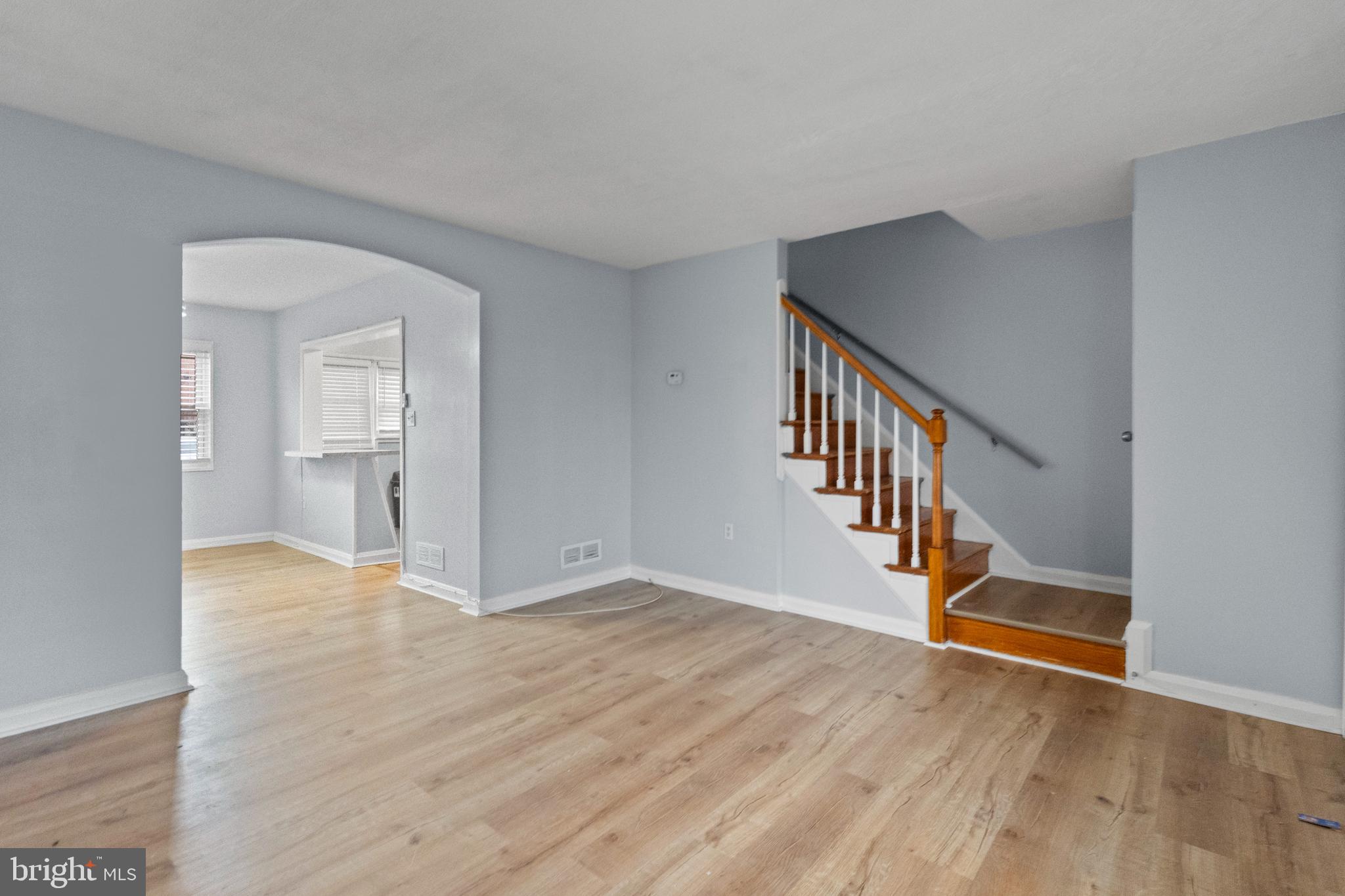 574 Brisbane Road Baltimore, MD 21229 - Photo 5 of 38 a view of an empty room with wooden floor and a kitchen