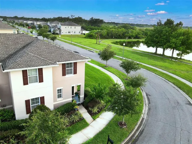an aerial view of a house with a yard and lake view