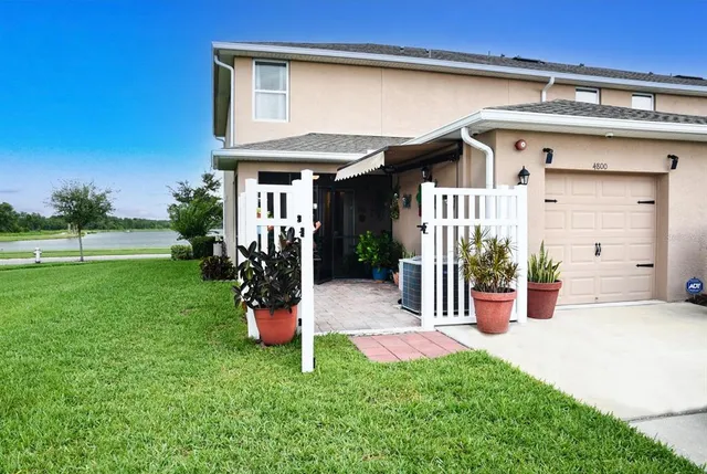 a balcony with table and chairs and potted plants