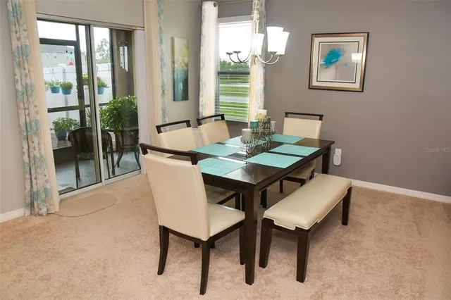 a view of a dining room with furniture and a potted plant