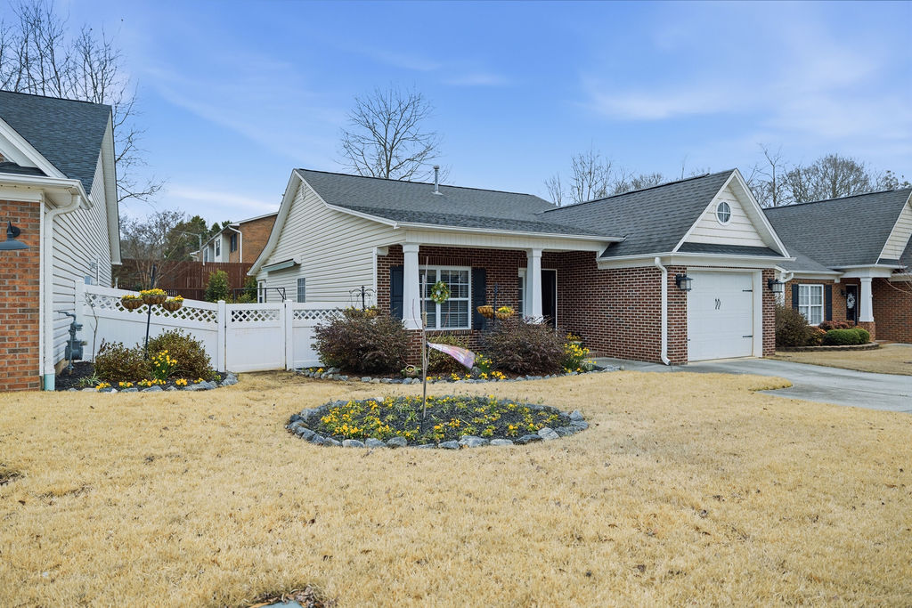 This charming home features a lovely facade, inviting garden, and a convenient attached garage.