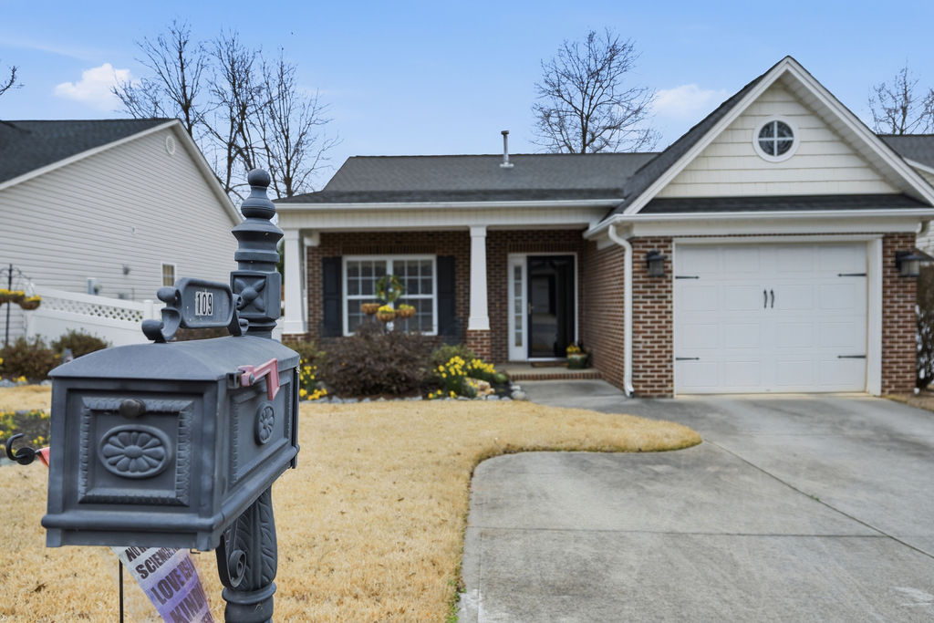 This charming home features a classic brick facade and an inviting front porch.
