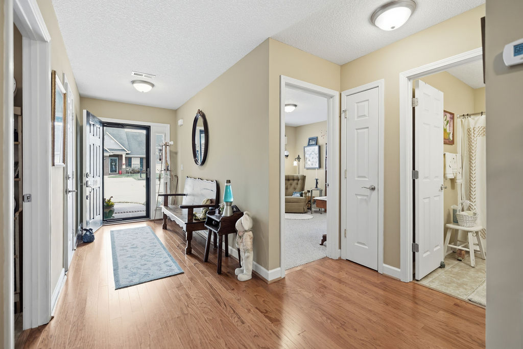 Enter this welcoming residence through a classic front door, revealing polished hardwood flooring throughout.