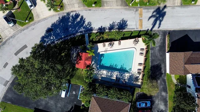 an aerial view of a house with swimming pool and outdoor seating