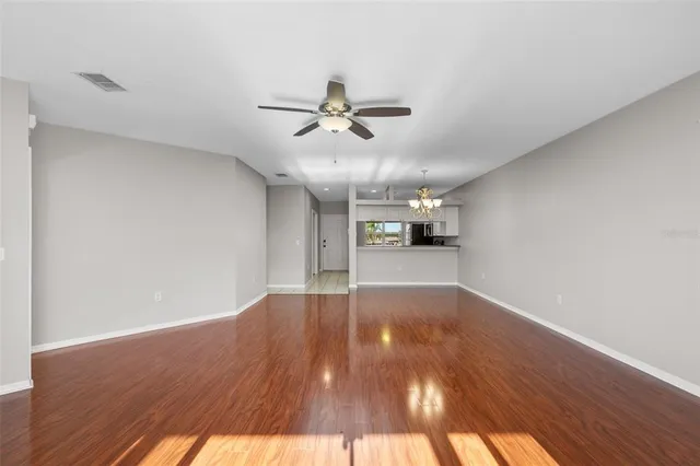 a view of a hallway with wooden floor and a living room