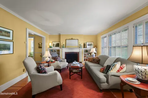 a living room with furniture fireplace and a large window