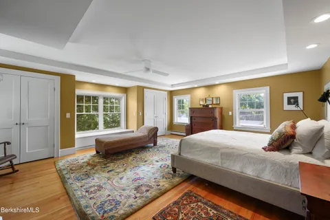a bedroom with a large bed and wooden floor