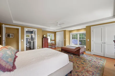 a spacious bedroom with a bed and glass window