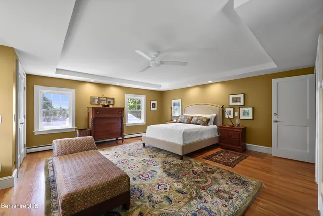 a bedroom with a large bed and wooden floor
