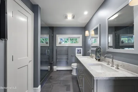 a bathroom with a double vanity sink toilet and shower