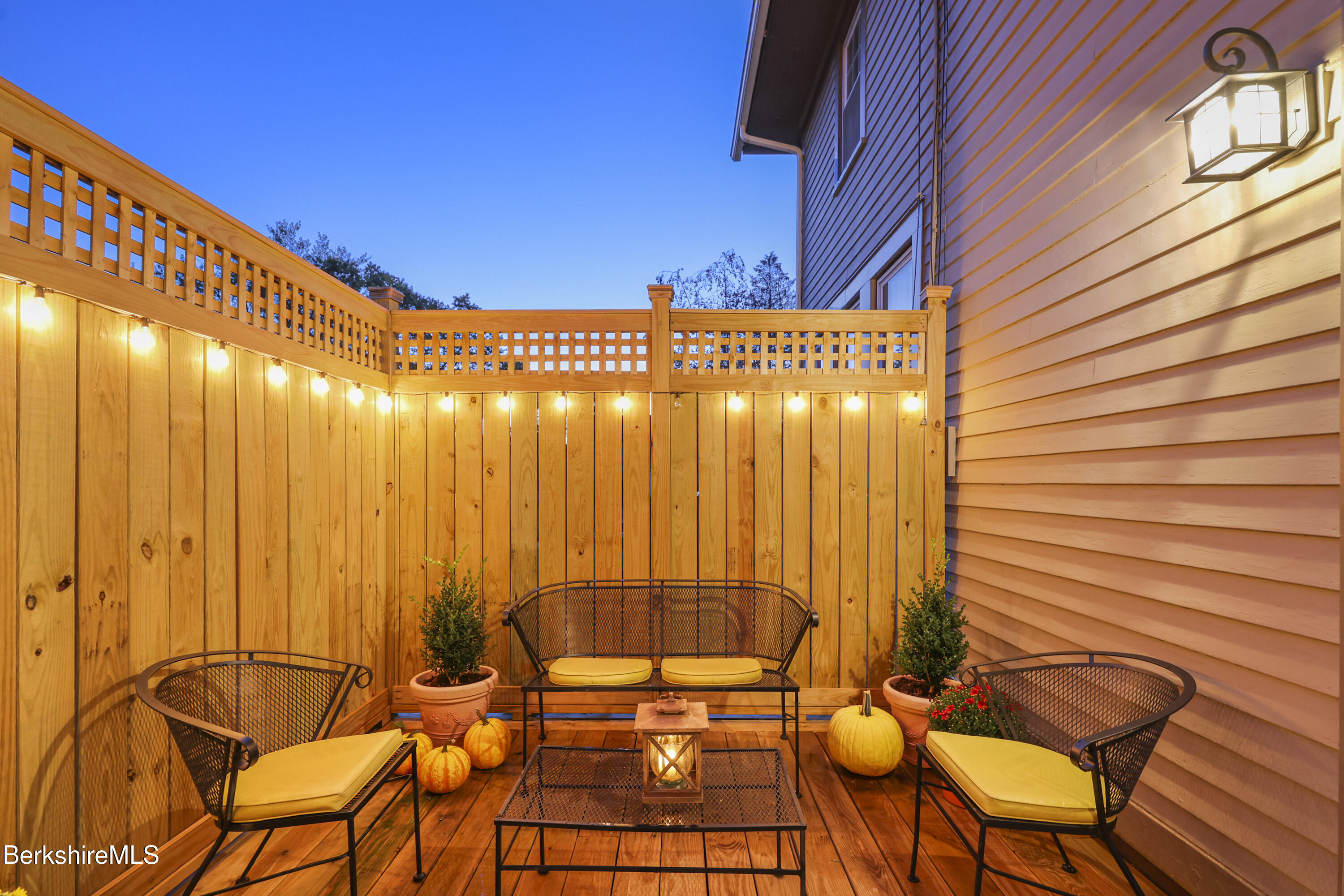39 Lexington Parkway Pittsfield, MA 01201 - Photo 42 of 48 a view of a patio with table and chairs with wooden floor and fence