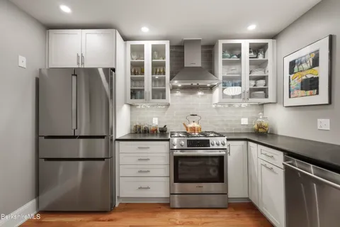 a kitchen with stainless steel appliances granite countertop a refrigerator and a stove top oven