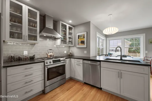 a kitchen with stainless steel appliances granite countertop a sink and cabinets
