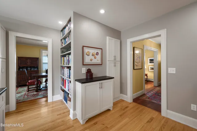 a view of a hallway with bathroom and wooden floor