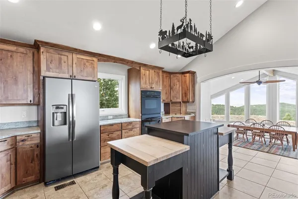 a kitchen with kitchen island a large counter top space appliances and cabinets