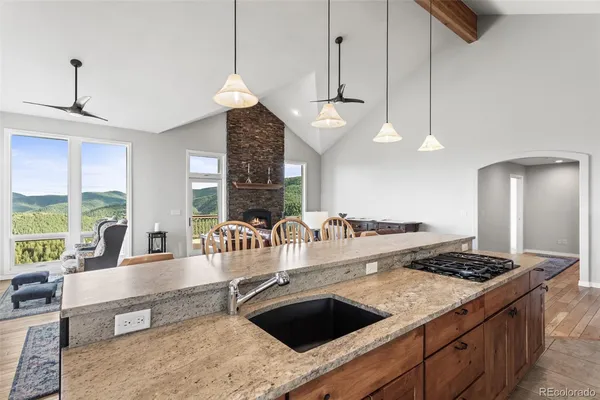 a kitchen with granite countertop a stove and white cabinets