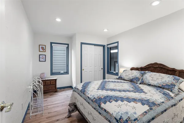 a bedroom with a bed and wooden floor