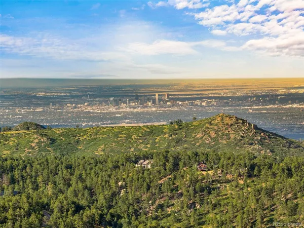 a view of a house with a mountain and a forest