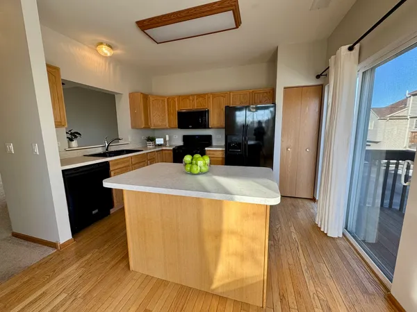 a kitchen with kitchen island wooden floors and stainless steel appliances
