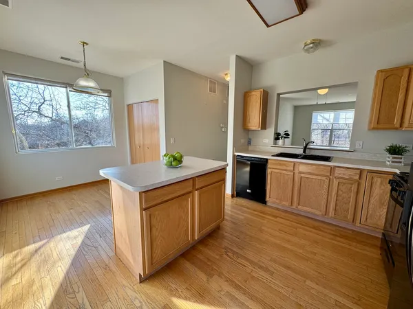 a kitchen with stainless steel appliances granite countertop a white cabinets a sink a stove a counter space and a window