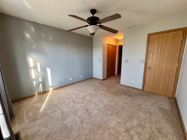 a view of a big room with chandelier fan and windows