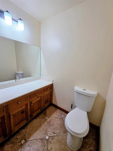 a bathroom with a granite countertop toilet and a sink