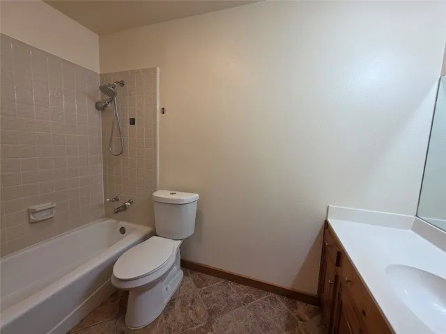 a white toilet sitting next to a bath tub